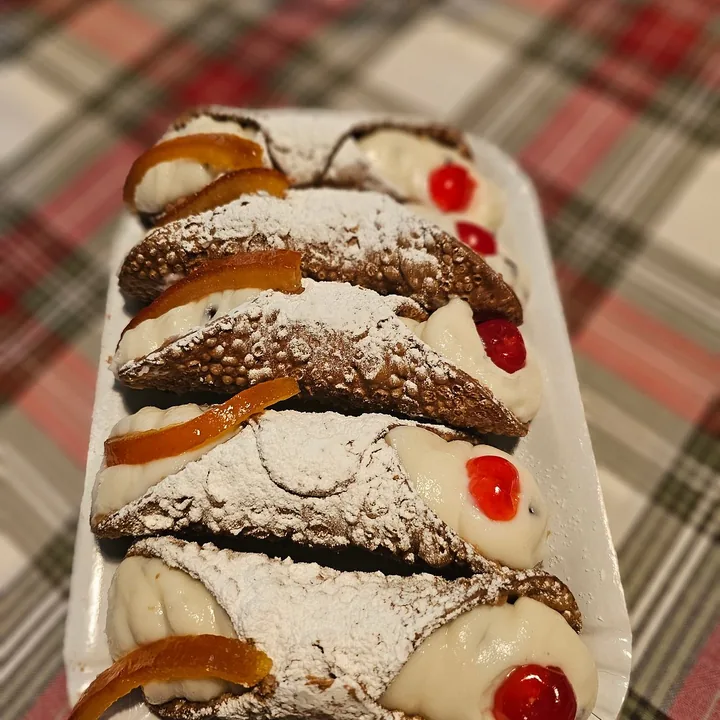 Cannoli siciliani su un vassoio, con la ricotta, la ciliegia candita e la scorza d'arancia.